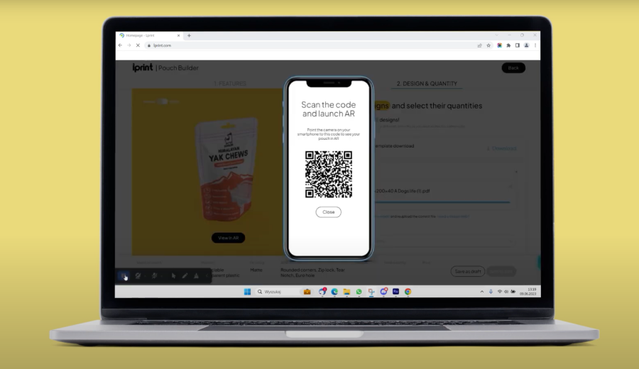 A laptop showing the Pouch Builder with the QR code that opens the configured pouch in AR on a phone